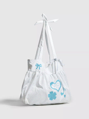 White polka dot canvas shoulder bag with blue heart appliqué and bow details.