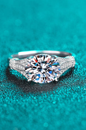 Silver pavé-set moissanite solitaire ring with intricate band detail.
