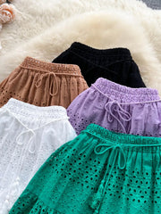 Delicate eyelet tiered maxi skirts in white, light brown, purple, green, and black with drawstring waists.