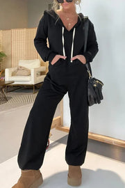 Black hooded jumpsuit with drawstring, wide leg, and pockets.