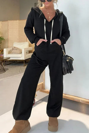 Black hooded jumpsuit with drawstring, wide leg, and pockets.