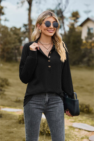 Black textured knit polo shirt with buttoned neckline and long sleeves.