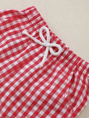 Baby shorts with red and white gingham pattern and drawstring waist.