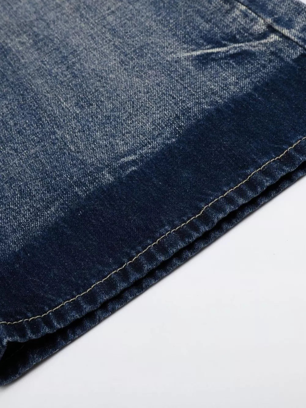 Men's blue distressed denim bootcut jeans, close-up of fabric texture and stitching detail.