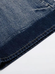 Men's blue distressed denim bootcut jeans, close-up of fabric texture and stitching detail.