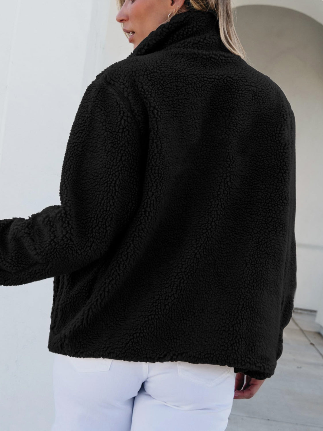 Black sherpa zip-up jacket with a stand-up collar and patch pockets.