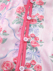 Pink floral and bow print maternity shirt with button-up front and ruffled trim.