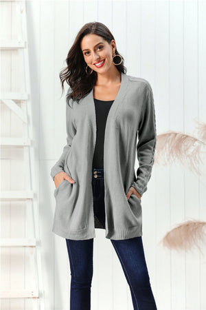 Gray cable knit open front cardigan with pockets and braided sleeve detail.