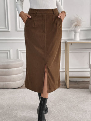 Brown corduroy midi skirt with a front slit and pockets, styled with black boots.