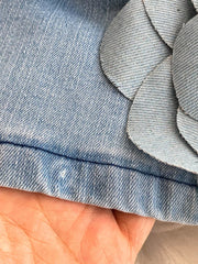 Blue denim dress detail with 3D floral applique embellishment.