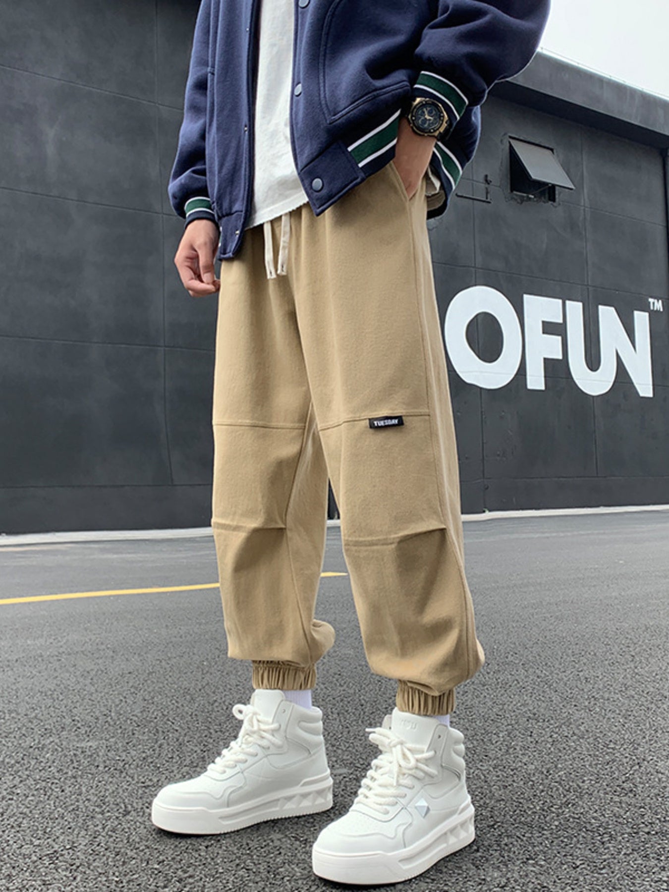 Khaki relaxed fit joggers with drawstring and pockets, featuring paneled knees.