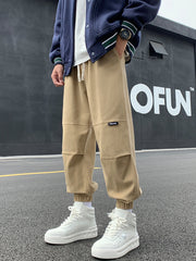 Khaki relaxed fit joggers with drawstring and pockets, featuring paneled knees.