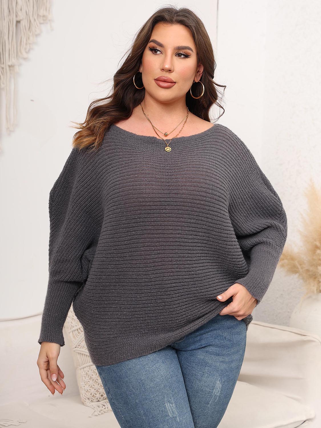 Off-shoulder charcoal ribbed knit sweater with batwing sleeves.