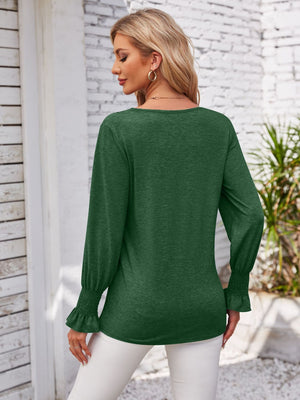 Dark green blouse with blouson sleeves and smocked cuffs.