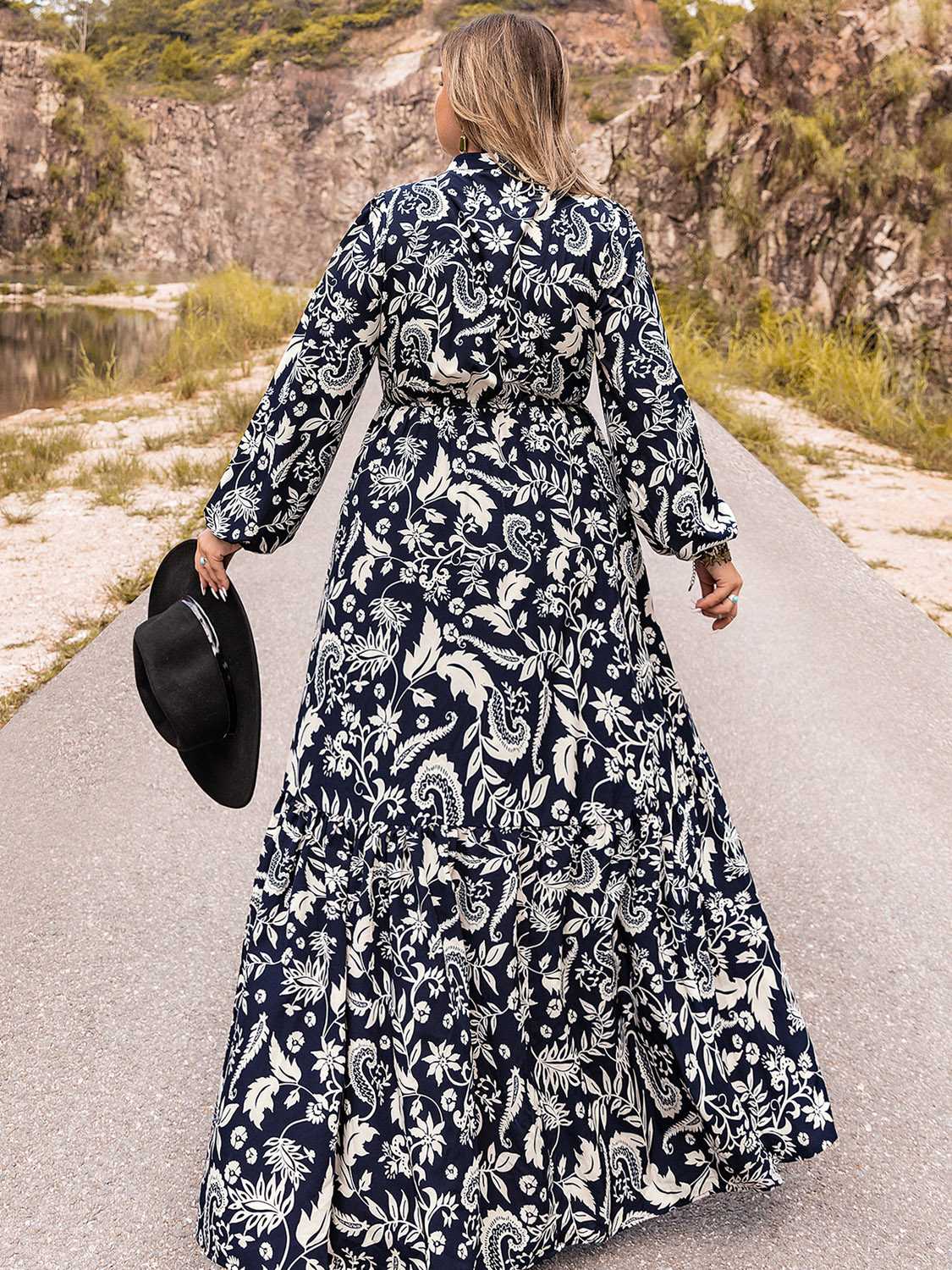 Dark navy paisley print tiered maxi dress with long sleeves and a tie waist.