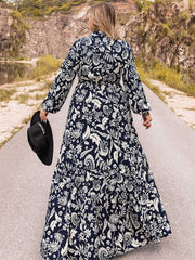 Dark navy paisley print tiered maxi dress with long sleeves and a tie waist.