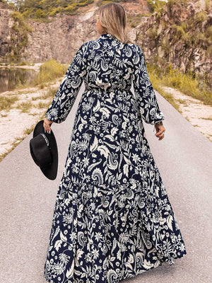 Dark navy paisley print tiered maxi dress with long sleeves and a tie waist.