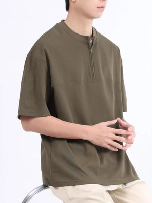 Men's dark green cotton half-zip t-shirt with a boxy fit.