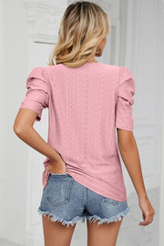 Blush pink perforated puff sleeve top with a textured diamond pattern.