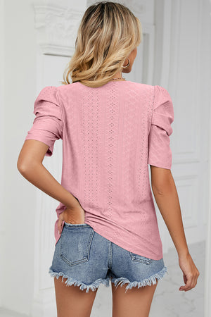 Blush pink perforated puff sleeve top with a textured diamond pattern.