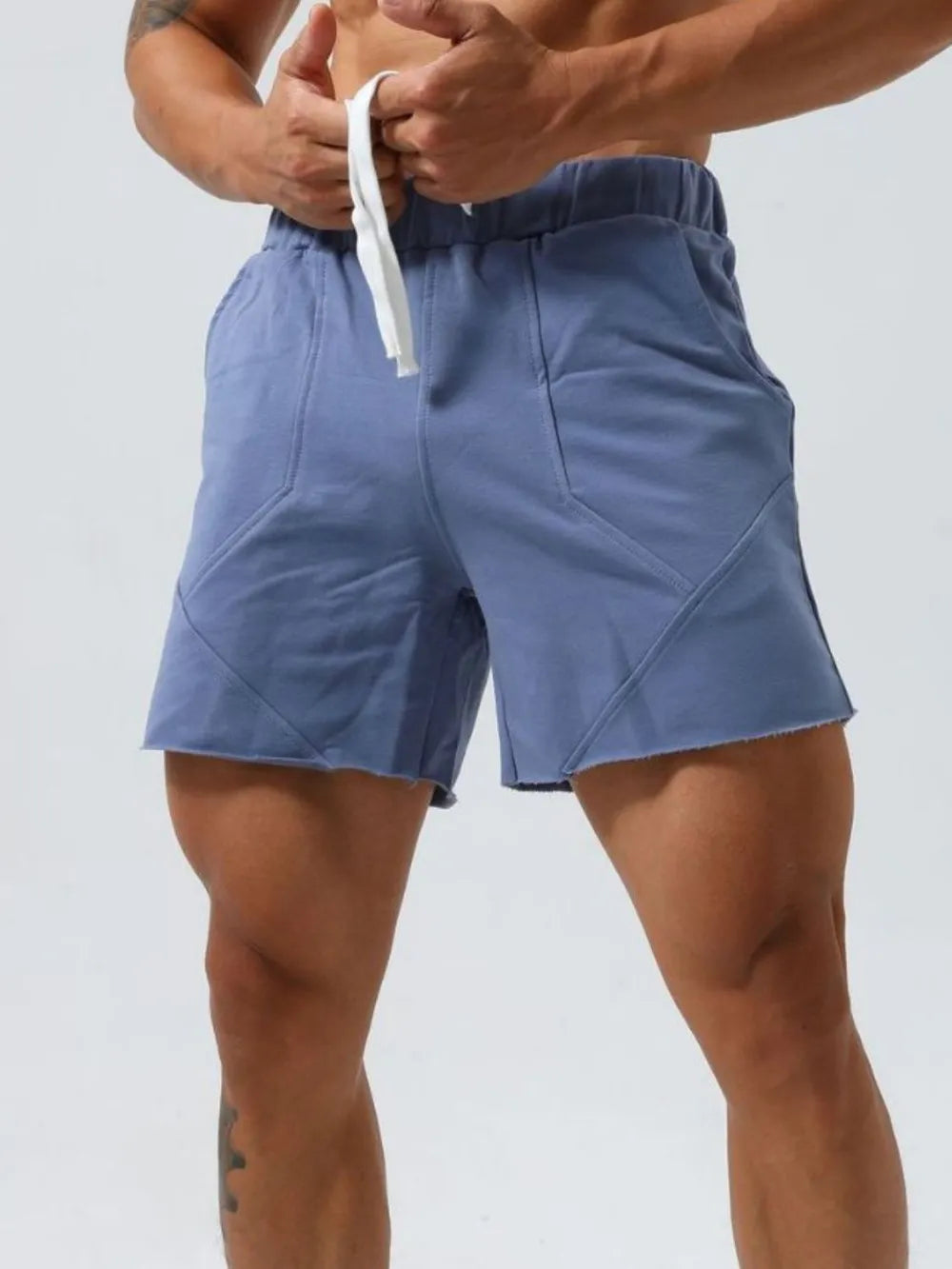 Dusty blue lounge shorts with raw-edge seams and drawstring waist.