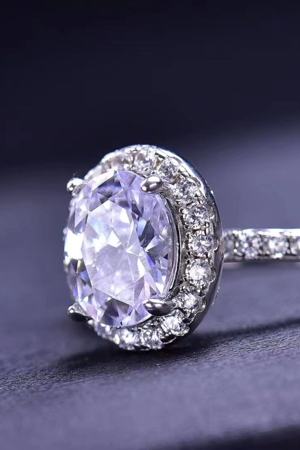 Halo oval diamond engagement ring in white with pave band.