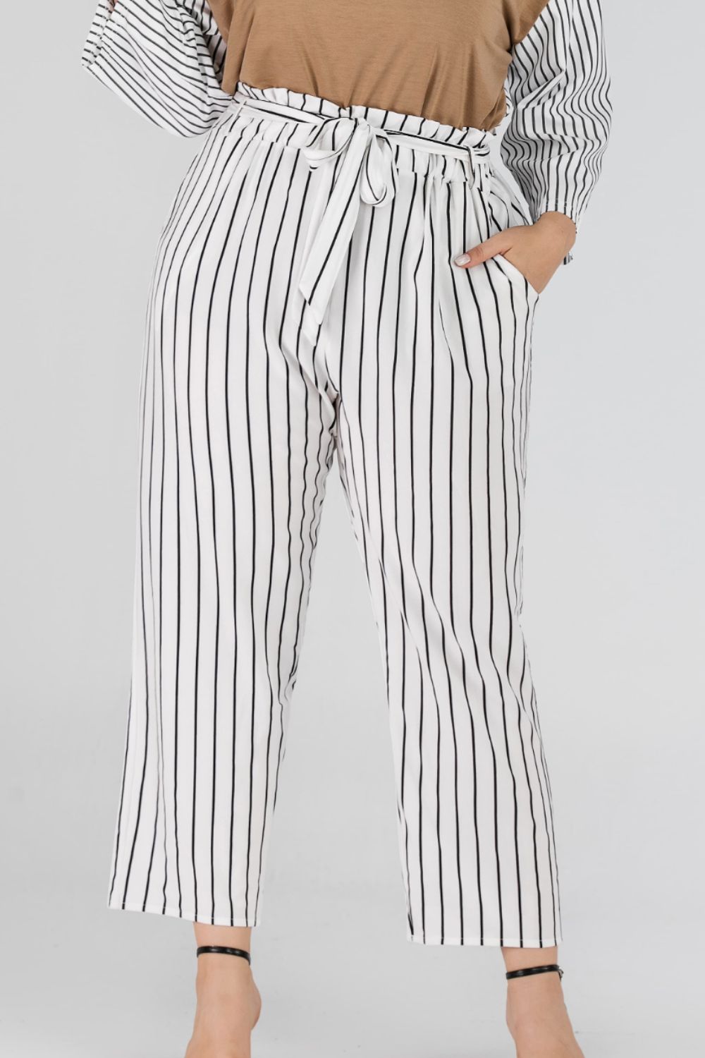 White paperbag waist trousers with black vertical stripes and a tie belt.
