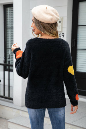 Black fluffy knit sweater with heart details on sleeves and back.