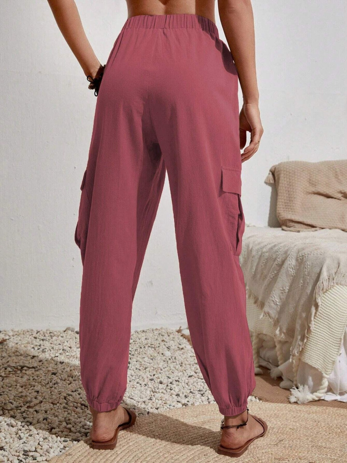Textured cargo lounge trousers in dusty pink with elastic waist and cuffs, and side cargo pockets.