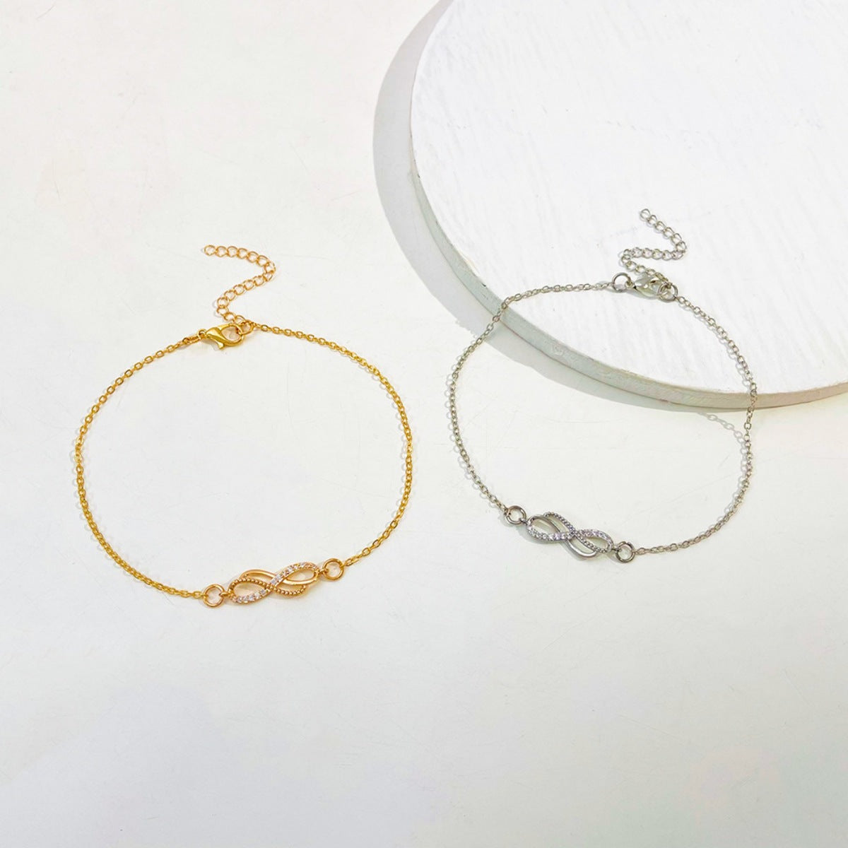 Gold and silver infinity knot charm bracelets with adjustable chains