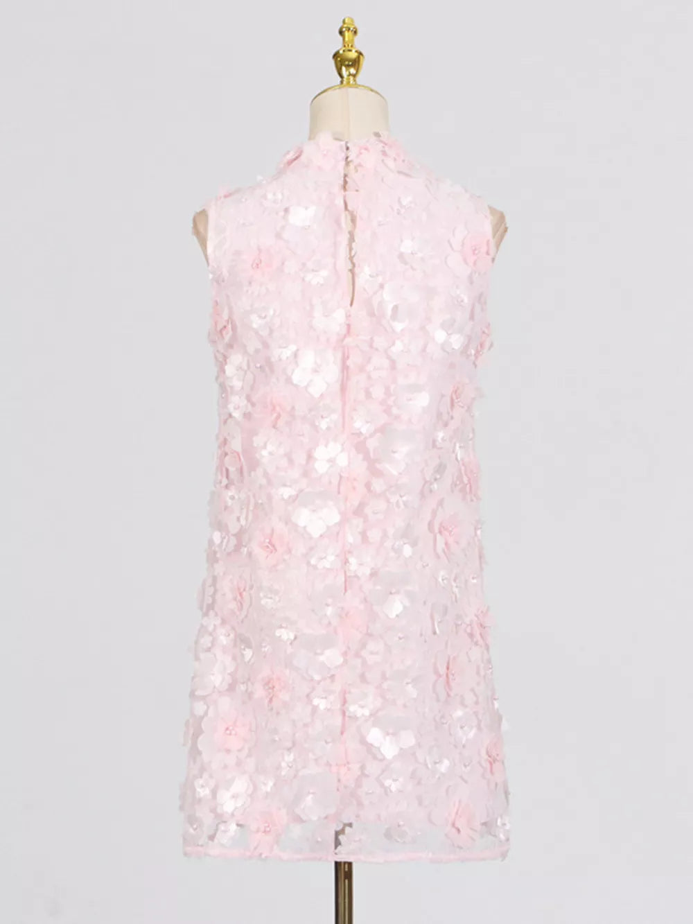 Pink floral applique mini dress with ruffled details and a mock neck.