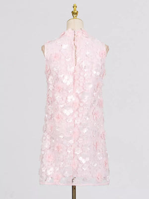 Pink floral applique mini dress with ruffled details and a mock neck.