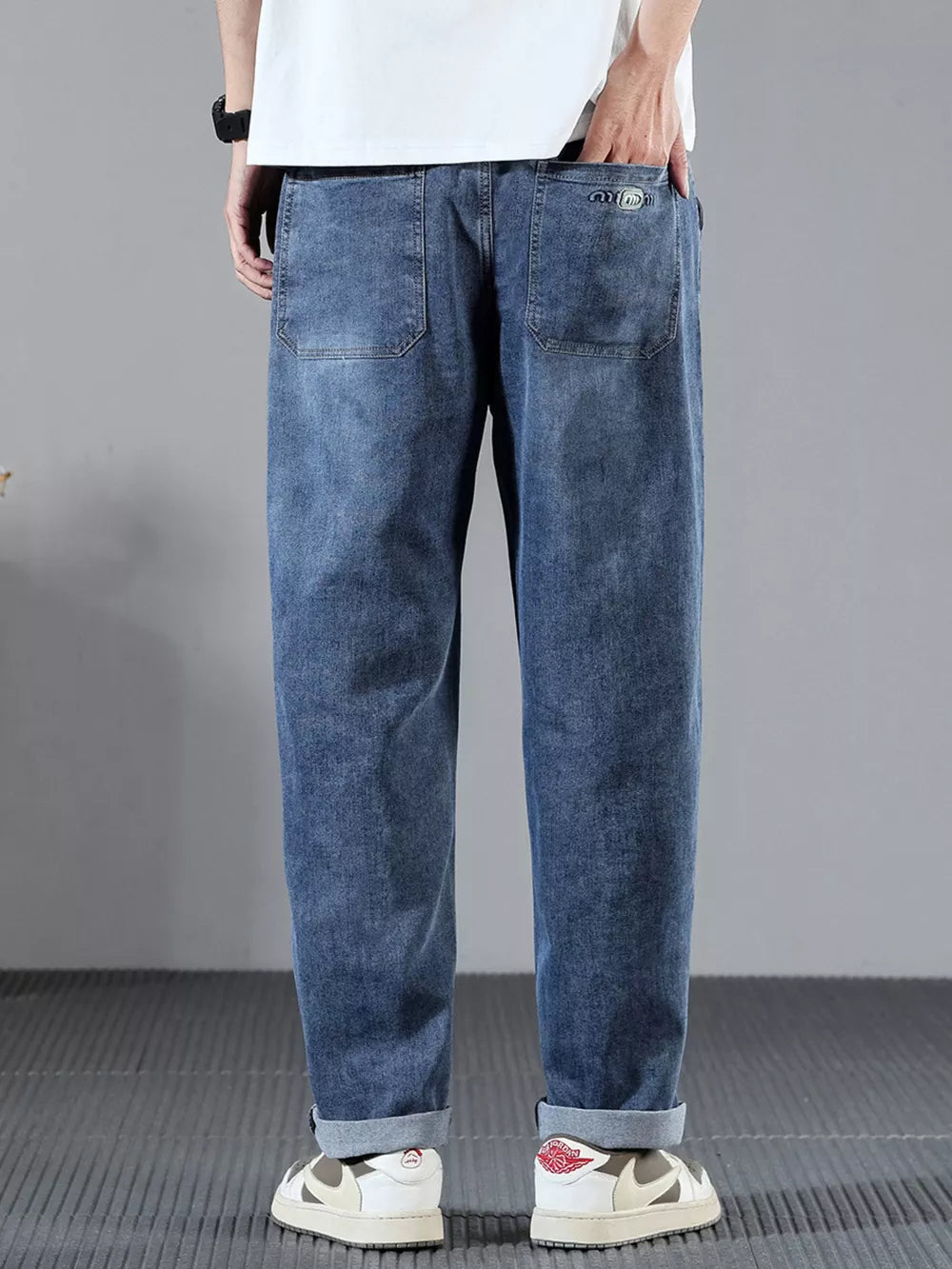 Men's blue denim jeans with wide leg and cuffed hems.