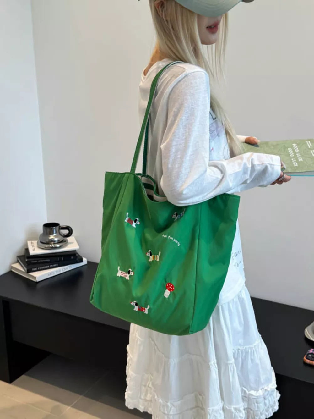 Green shoulder bag with embroidered dachshunds and a mushroom detail.
