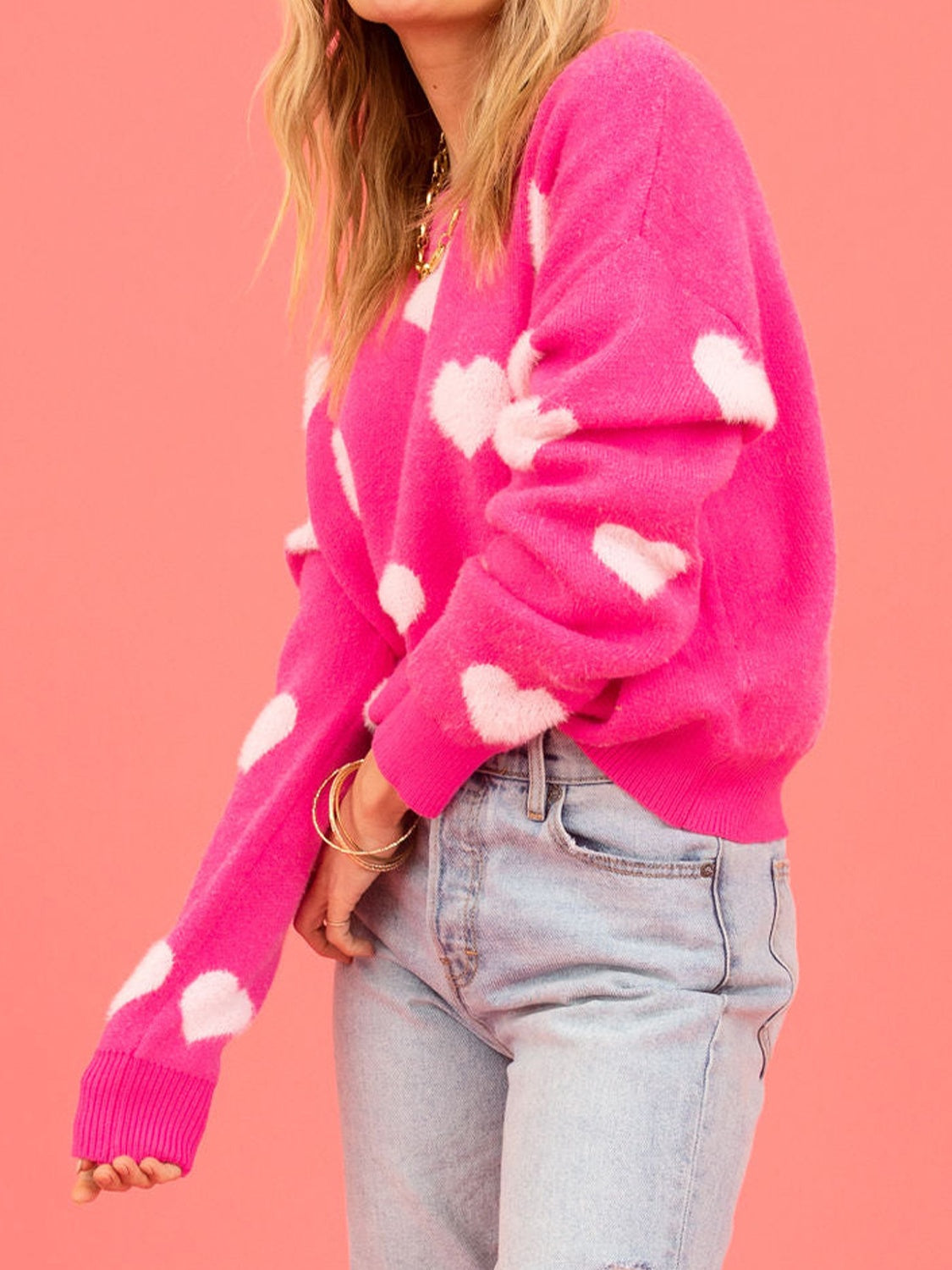 Fuchsia pink crewneck sweater with white intarsia hearts, crew neck, long sleeves.