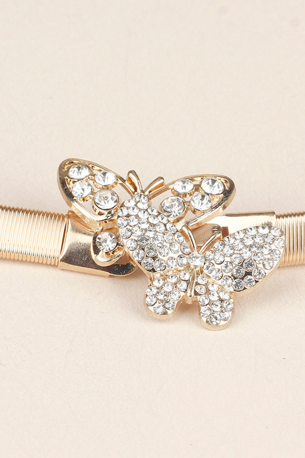 Gold belt with a double crystal butterfly clasp closure.