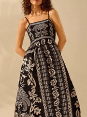 Black floral print spaghetti strap maxi dress with a-line cut and bohemian details.