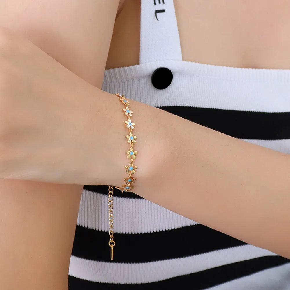 Gold daisy chain bracelet with turquoise enamel centers, 18K gold-plated.