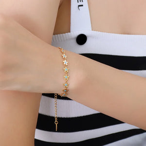 Gold daisy chain bracelet with turquoise enamel centers, 18K gold-plated.