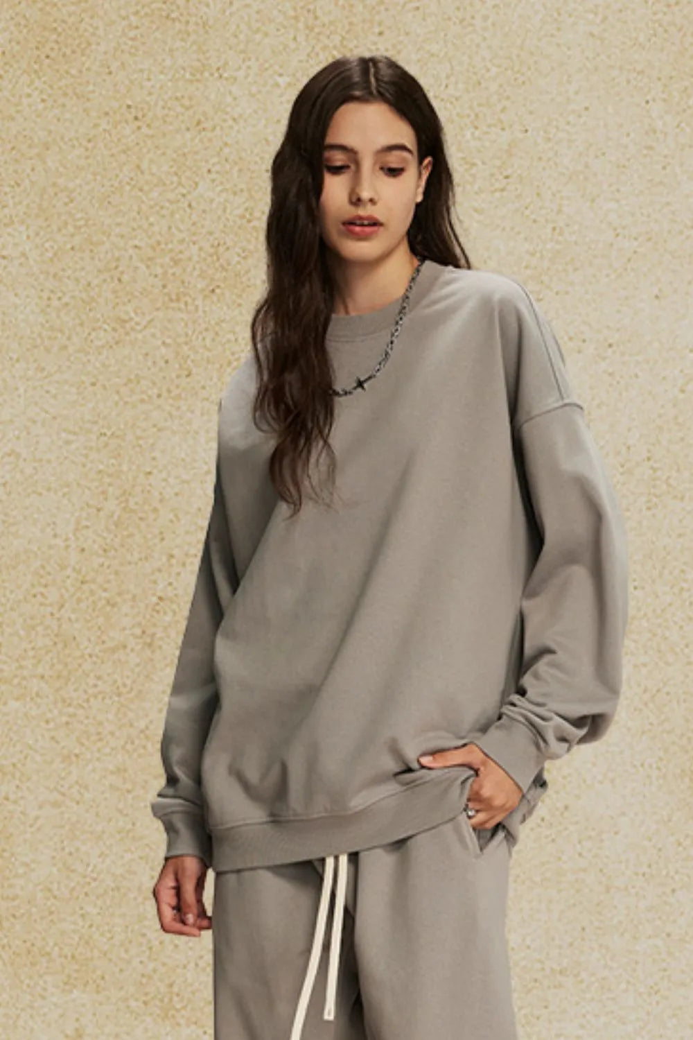 Oversized gray crewneck sweatshirt with subtle shoulders and a relaxed fit.