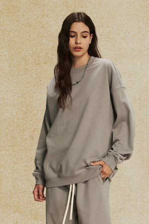 Oversized gray crewneck sweatshirt with subtle shoulders and a relaxed fit.