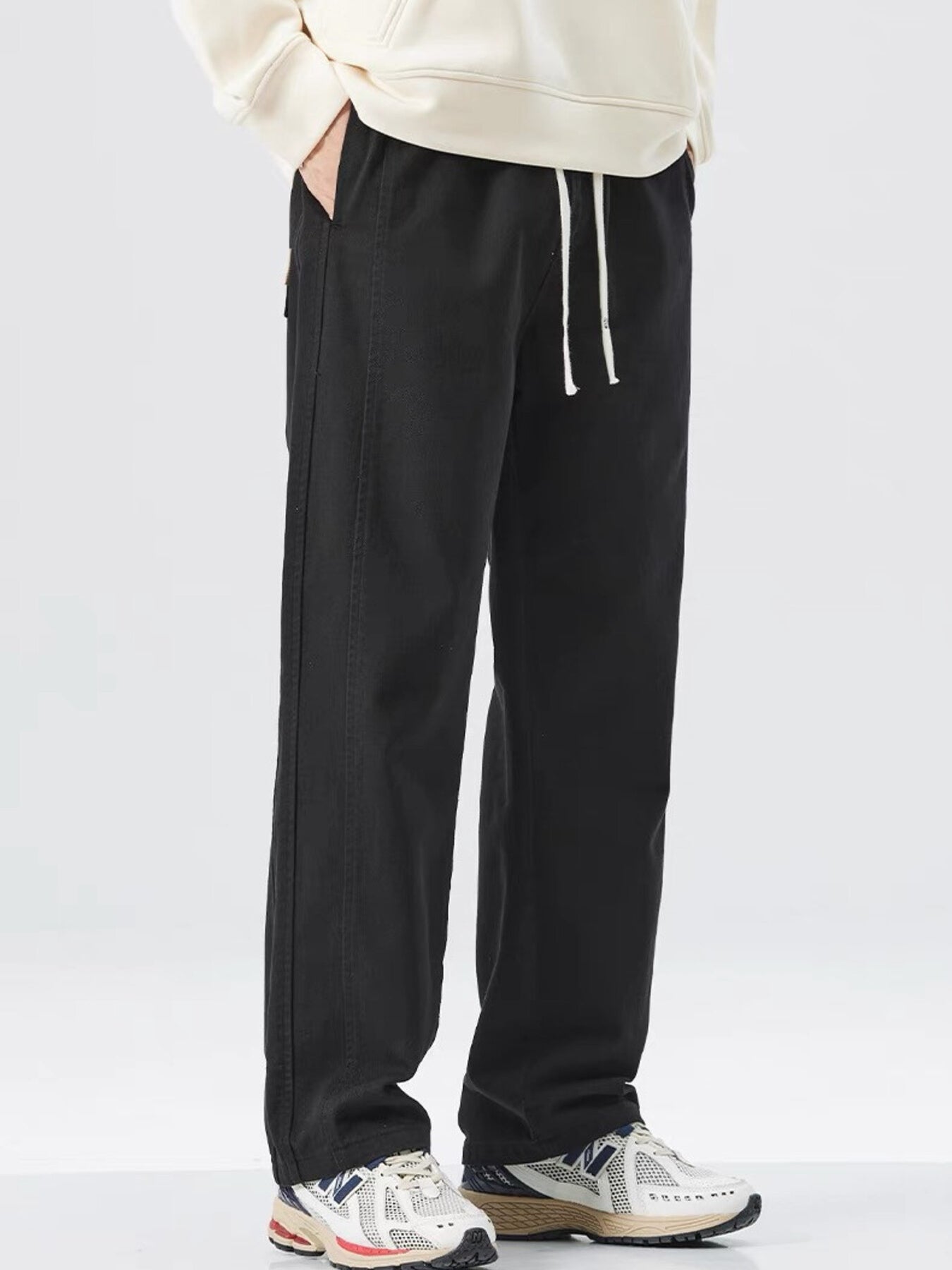 Men's black loose fit drawstring sweatpants with white drawstrings.
