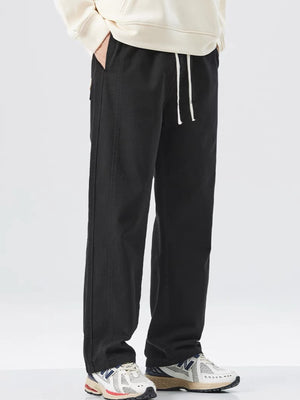 Men's black loose fit drawstring sweatpants with white drawstrings.