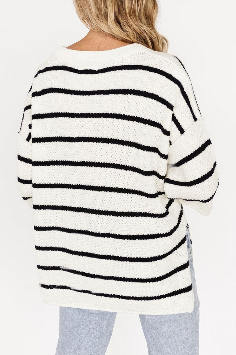 White and black striped knit pullover sweater with a crew neck and relaxed fit.