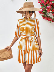 Vertical stripe shirred waist dress in gold with tie belt and tiered skirt.