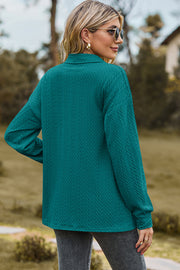 Teal textured polo-neck sweater with button detail and long sleeves.