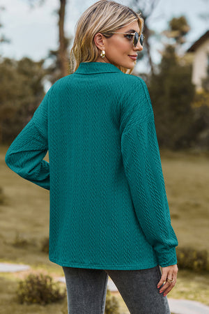 Teal textured polo-neck sweater with button detail and long sleeves.