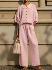 Pink linen two-piece set with button-down top, Peter Pan collar, puff sleeves, and wide-leg drawstring pants.