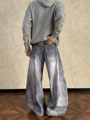 Men's vintage wash wide leg jeans in grey denim with curved seams.