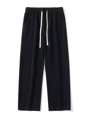Black relaxed fit drawstring pants with elastic waist and white drawcords.
